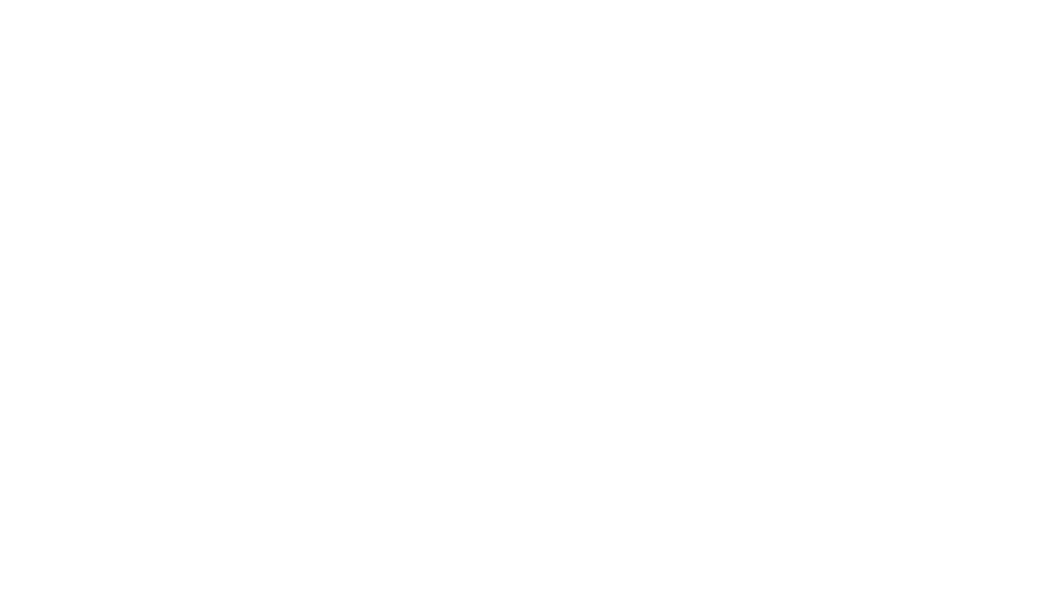 A dog wearing oval glasses is reading a book with a lightbulb to their left for light, and a pile of books on their right.